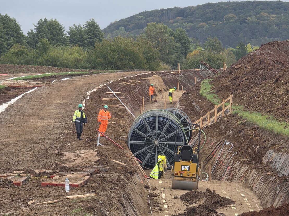 Offene Kabeltrasse in einem drainierten Acker